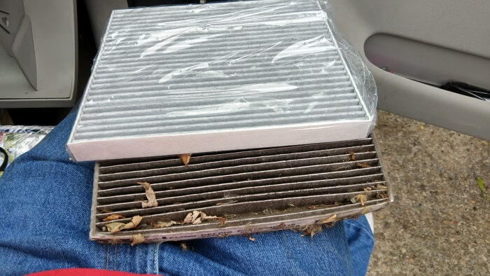The old cabin air filter next to the dirty cabin air filter.