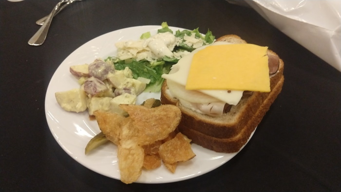 Lunch consisted of a roast beef and cheese sandwich, salad, potato salad, and chips.
