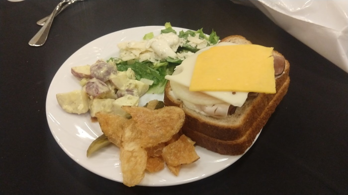 Lunch consisted of a roast beef and cheese sandwich, salad, potato salad, and chips.