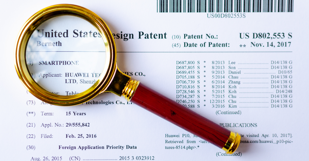 Magnifying glass laying on a patent application.